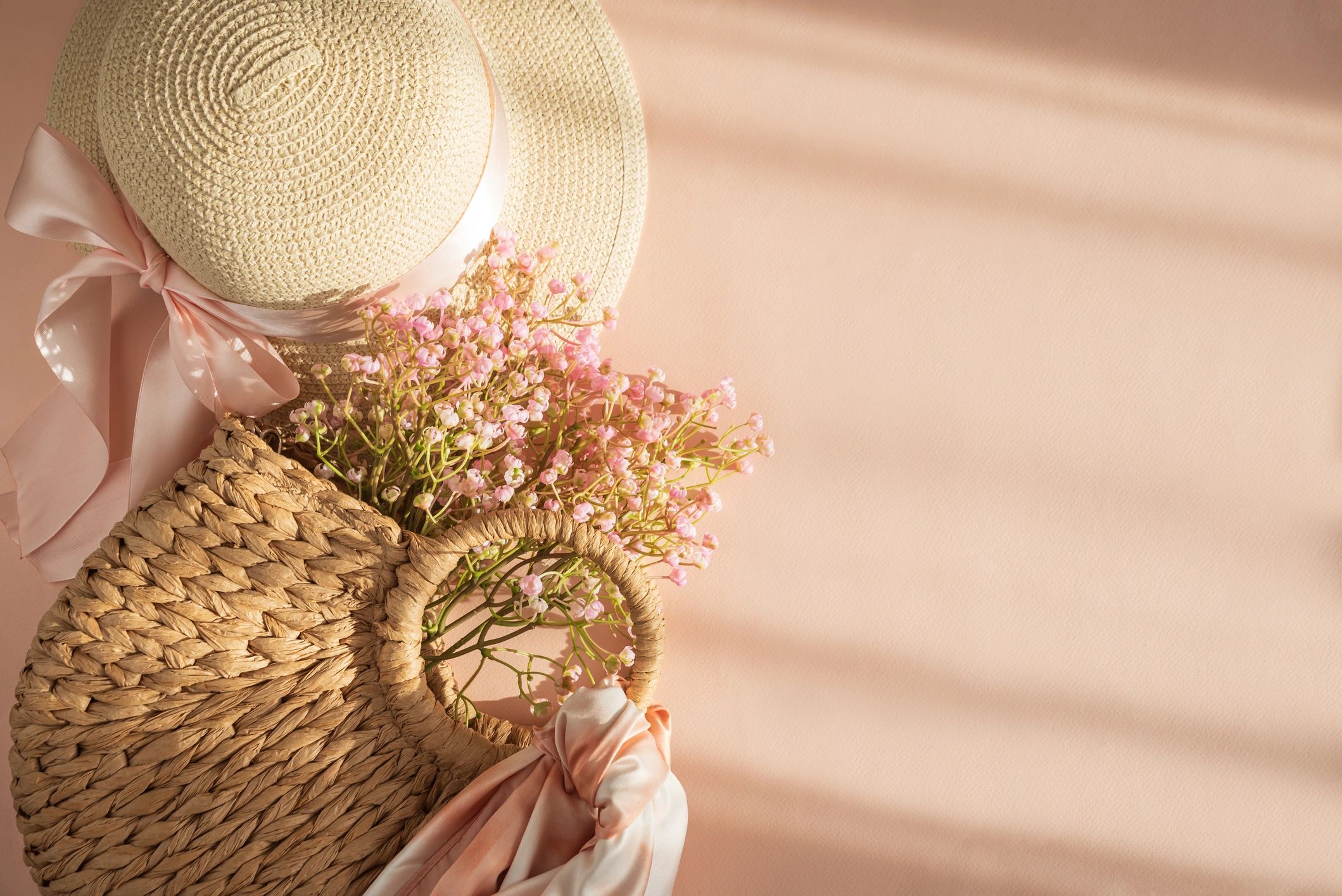 Elegant fashion flatlay with hats, handbag, and flowers